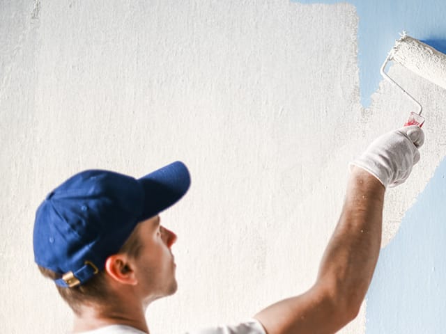 Painter rolling finish coat onto a prepared wall