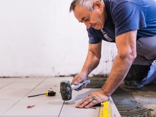 Tile setter laying floor tile